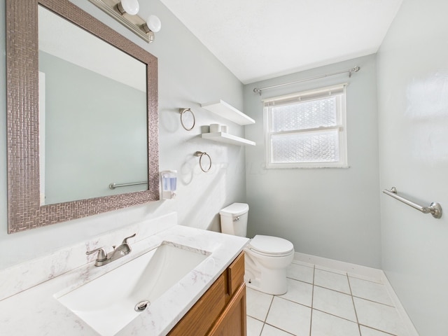 half bath with tile patterned floors, toilet, vanity, and baseboards