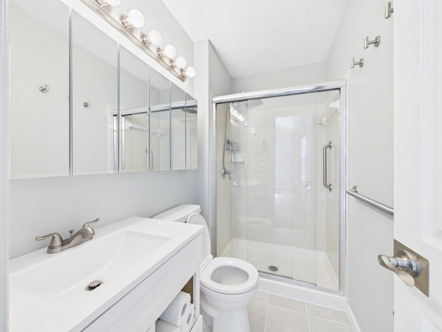 bathroom with toilet, a stall shower, tile patterned floors, a textured ceiling, and vanity