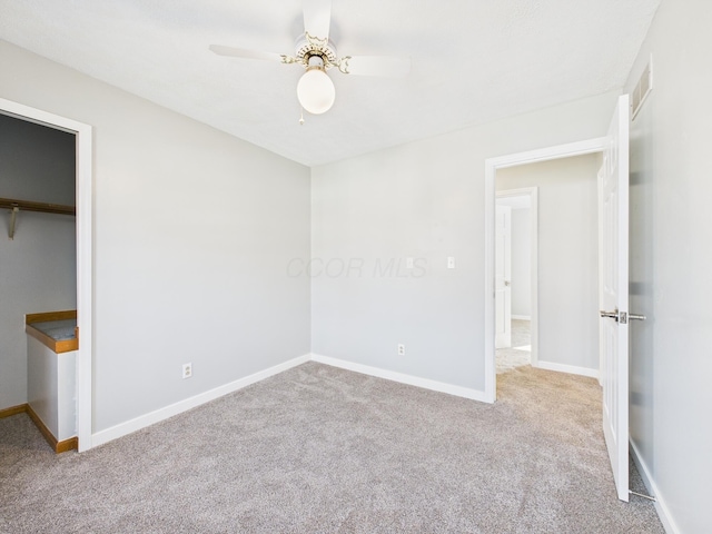 unfurnished bedroom featuring carpet flooring, visible vents, a ceiling fan, and baseboards