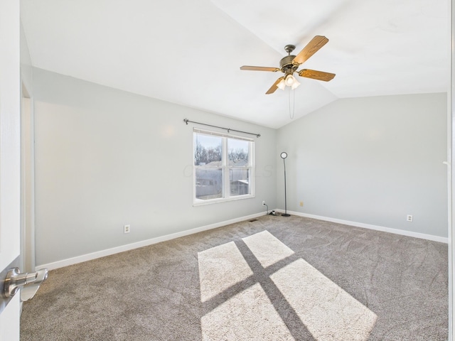 carpeted spare room with baseboards, a ceiling fan, and vaulted ceiling