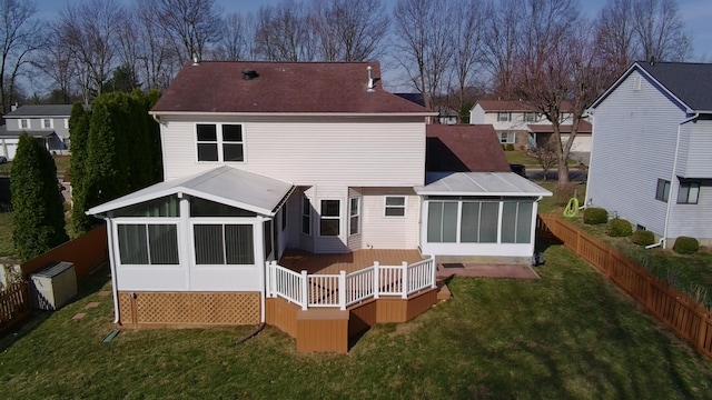 back of house with a lawn, fence, and a sunroom