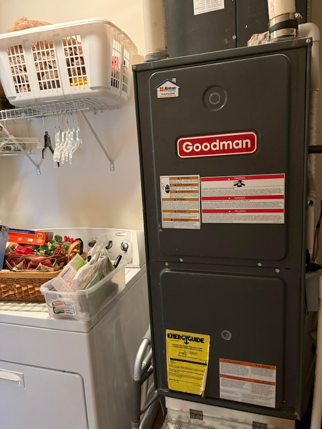 utility room with heating unit and washer / dryer