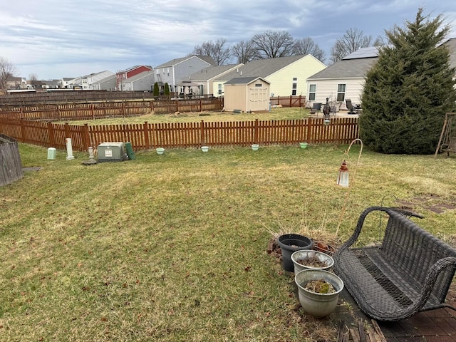 view of yard with an outbuilding, a residential view, a storage unit, and fence