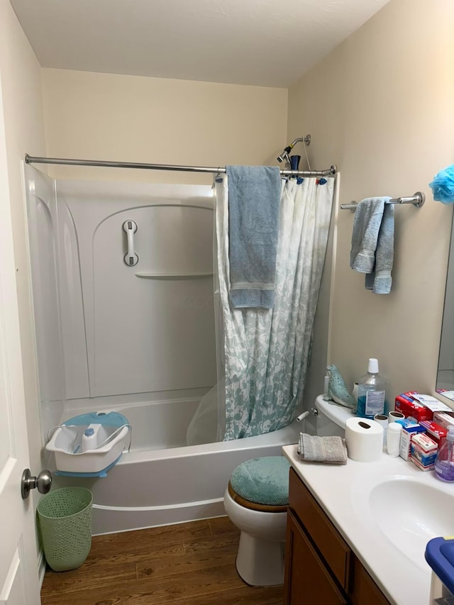 bathroom with toilet, wood finished floors, vanity, and shower / bath combination with curtain