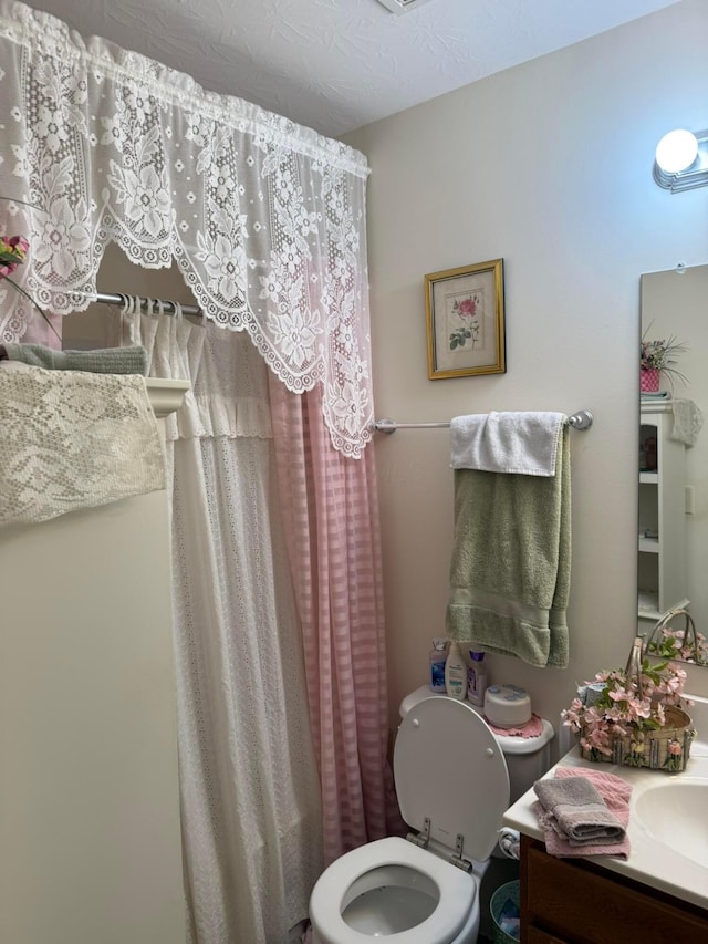 full bath featuring curtained shower, toilet, and vanity