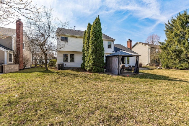 rear view of house featuring a gazebo, central air condition unit, a patio, and a yard