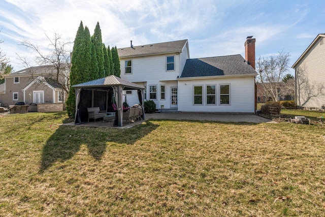 rear view of property featuring a gazebo, a yard, a patio, and a chimney