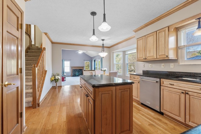 kitchen featuring pendant lighting, stainless steel dishwasher, a textured ceiling, a center island, and light wood-style floors