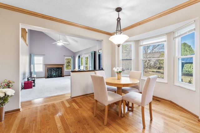 dining space with lofted ceiling, a healthy amount of sunlight, and light wood-style floors