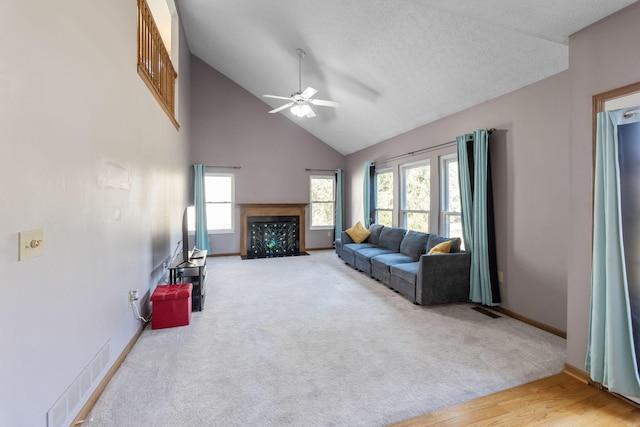 carpeted living room featuring high vaulted ceiling, baseboards, visible vents, and ceiling fan