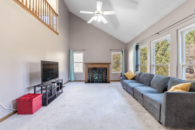 living area with a fireplace with flush hearth, high vaulted ceiling, carpet flooring, baseboards, and ceiling fan