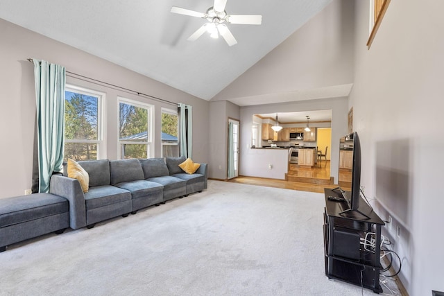 living room featuring light carpet, ceiling fan, high vaulted ceiling, and baseboards