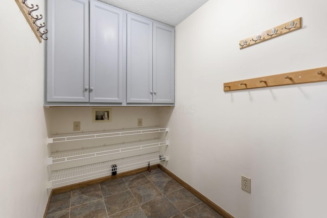 clothes washing area featuring washer hookup, cabinet space, baseboards, and a textured ceiling