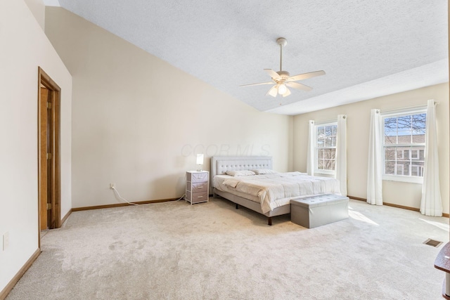 bedroom with lofted ceiling, light colored carpet, baseboards, and a textured ceiling