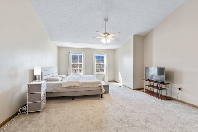 bedroom with a textured ceiling, ceiling fan, baseboards, and light carpet