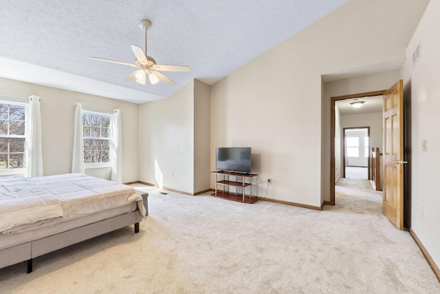 bedroom featuring visible vents, baseboards, vaulted ceiling, light carpet, and a textured ceiling