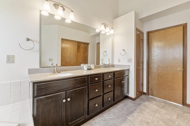 bathroom with a sink, baseboards, and double vanity