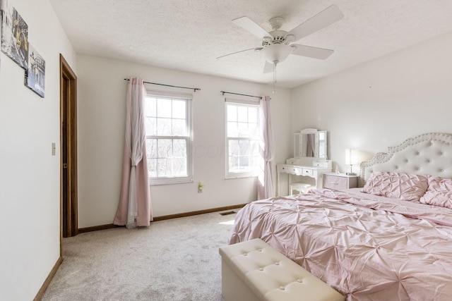 bedroom with visible vents, a ceiling fan, a textured ceiling, carpet floors, and baseboards