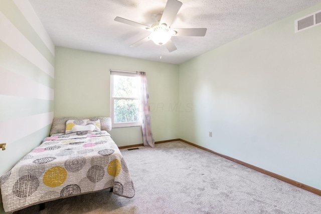 bedroom featuring visible vents, carpet floors, a textured ceiling, and baseboards