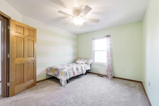 bedroom with visible vents, ceiling fan, baseboards, light carpet, and a textured ceiling