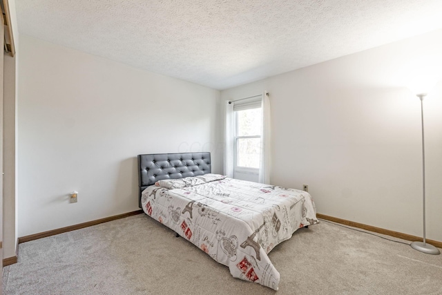 carpeted bedroom with baseboards and a textured ceiling