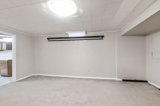 spare room featuring baseboards and light carpet