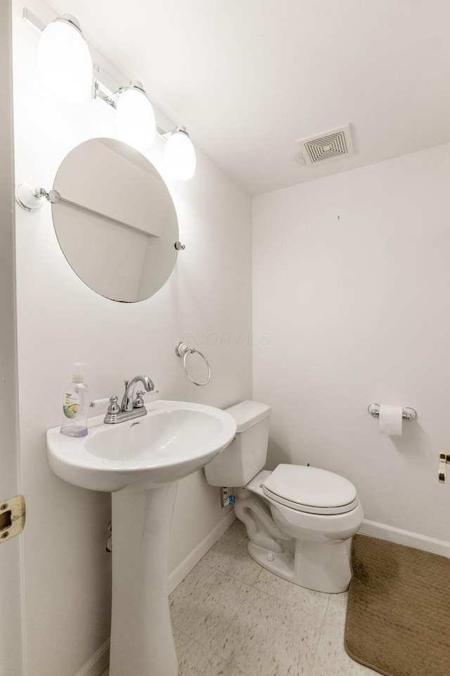 bathroom with visible vents, baseboards, and toilet