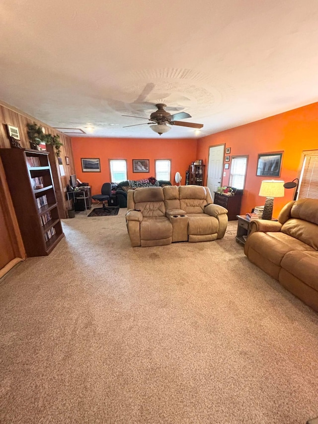 carpeted living room with ceiling fan