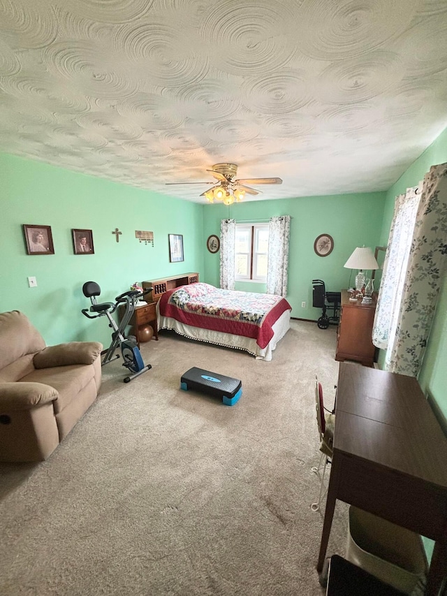 bedroom featuring carpet flooring, a ceiling fan, and a textured ceiling