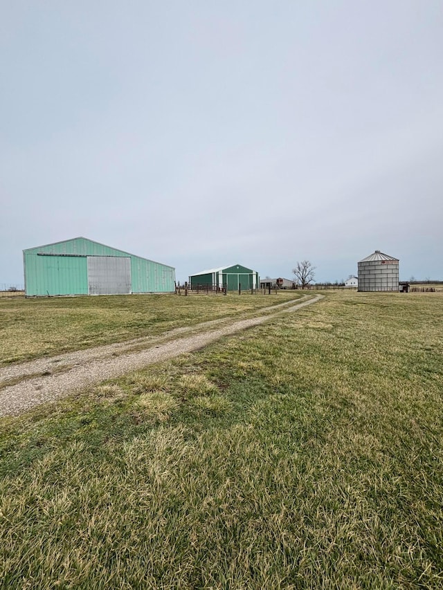 view of yard featuring an outbuilding, a rural view, and a pole building