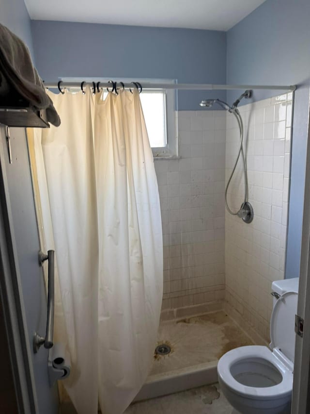 full bath featuring a stall shower and toilet