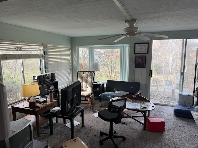 home office with a ceiling fan, carpet floors, and a textured ceiling