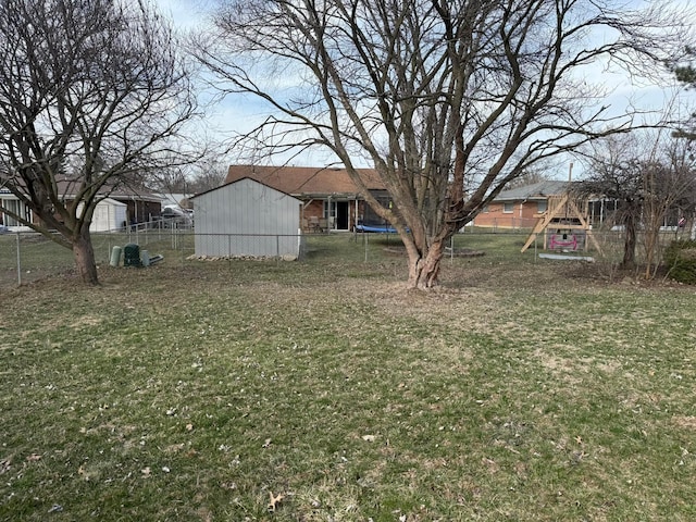 view of yard featuring a playground, a trampoline, and fence