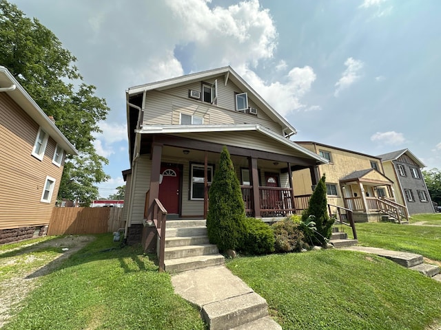 view of front of property featuring a porch, a front yard, and fence