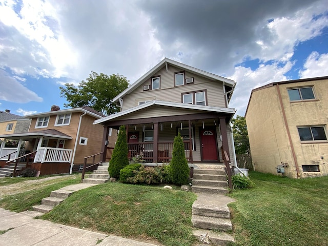 american foursquare style home with a porch and a front yard