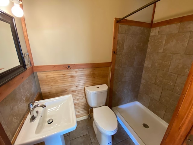 full bath with a sink, toilet, wainscoting, and a shower stall