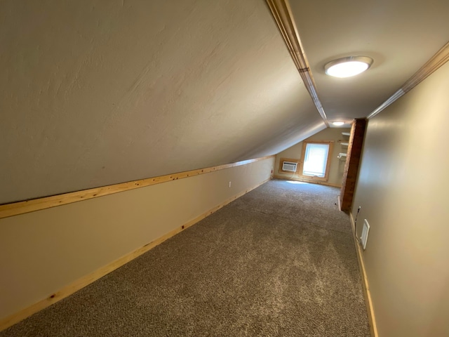 bonus room with baseboards, vaulted ceiling, carpet flooring, and a wall mounted AC