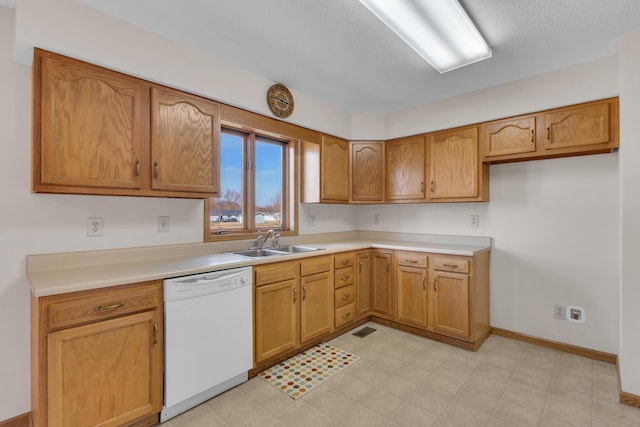 kitchen with visible vents, light floors, light countertops, white dishwasher, and a sink