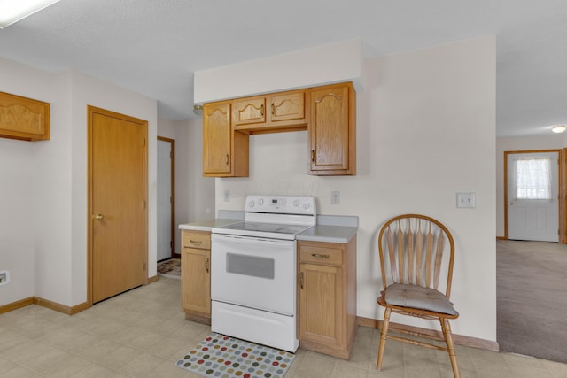 kitchen featuring white electric stove, light countertops, and baseboards