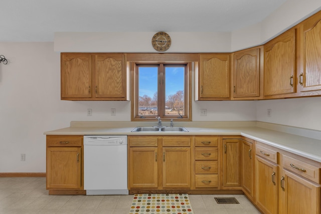 kitchen with baseboards, visible vents, a sink, light countertops, and dishwasher