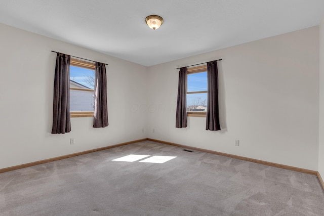 carpeted empty room with visible vents and baseboards