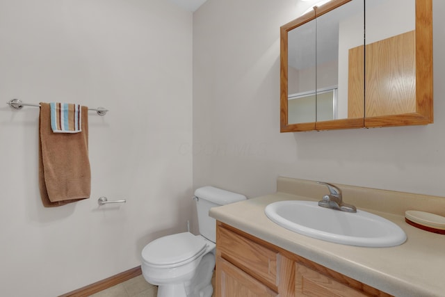 bathroom with vanity, tile patterned floors, and toilet