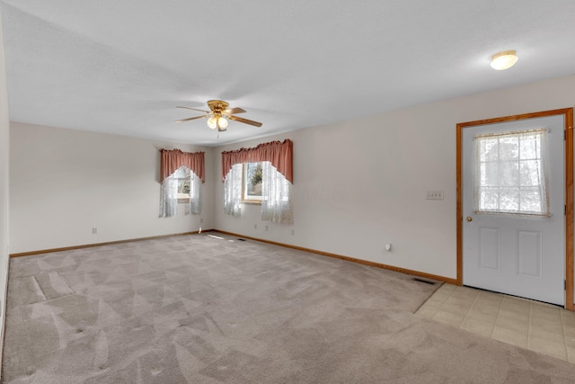 interior space with visible vents, baseboards, and ceiling fan