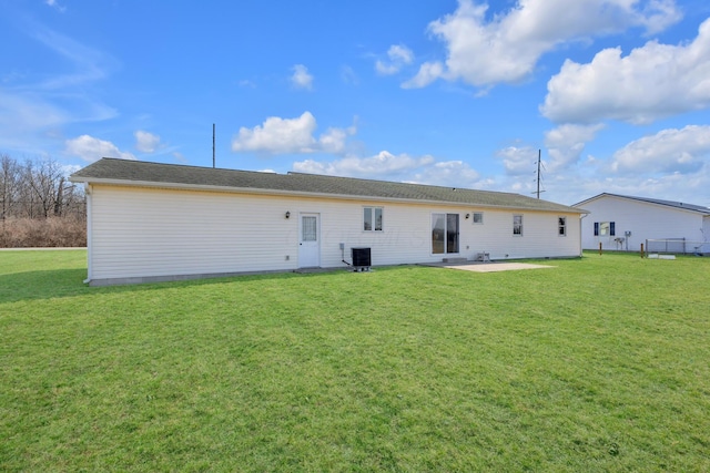 rear view of house with central air condition unit, a lawn, and a patio