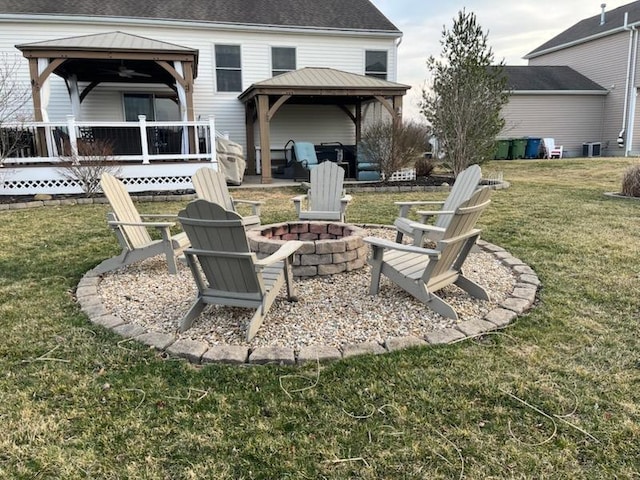 view of yard with a gazebo, a wooden deck, and an outdoor fire pit