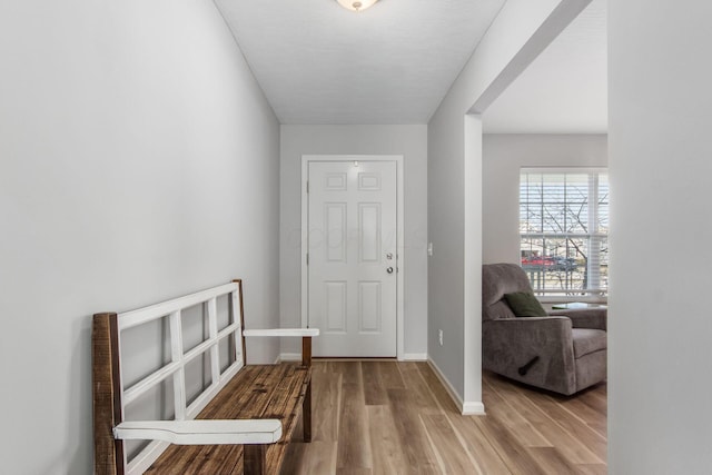 foyer featuring baseboards and wood finished floors