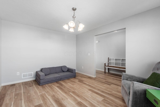 sitting room featuring an inviting chandelier, baseboards, visible vents, and light wood-type flooring