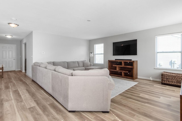 living room with light wood-style flooring and baseboards