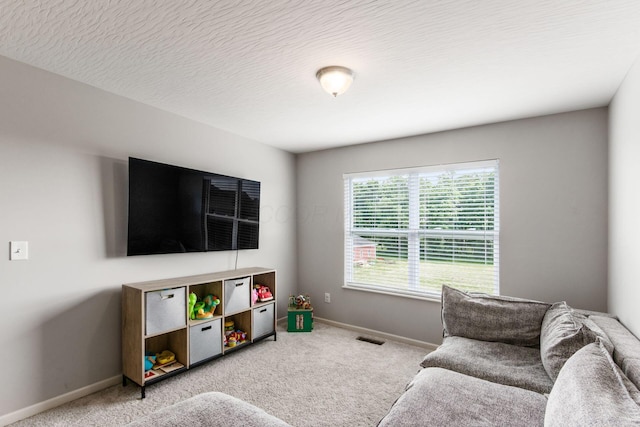 living area with visible vents, baseboards, a textured ceiling, and carpet flooring