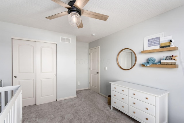 bedroom featuring baseboards, visible vents, ceiling fan, a closet, and light carpet